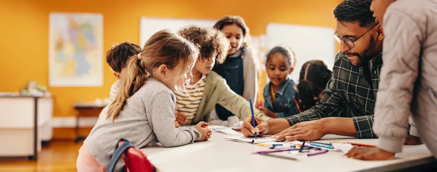 Teacher working with a group of children on an activity at a table